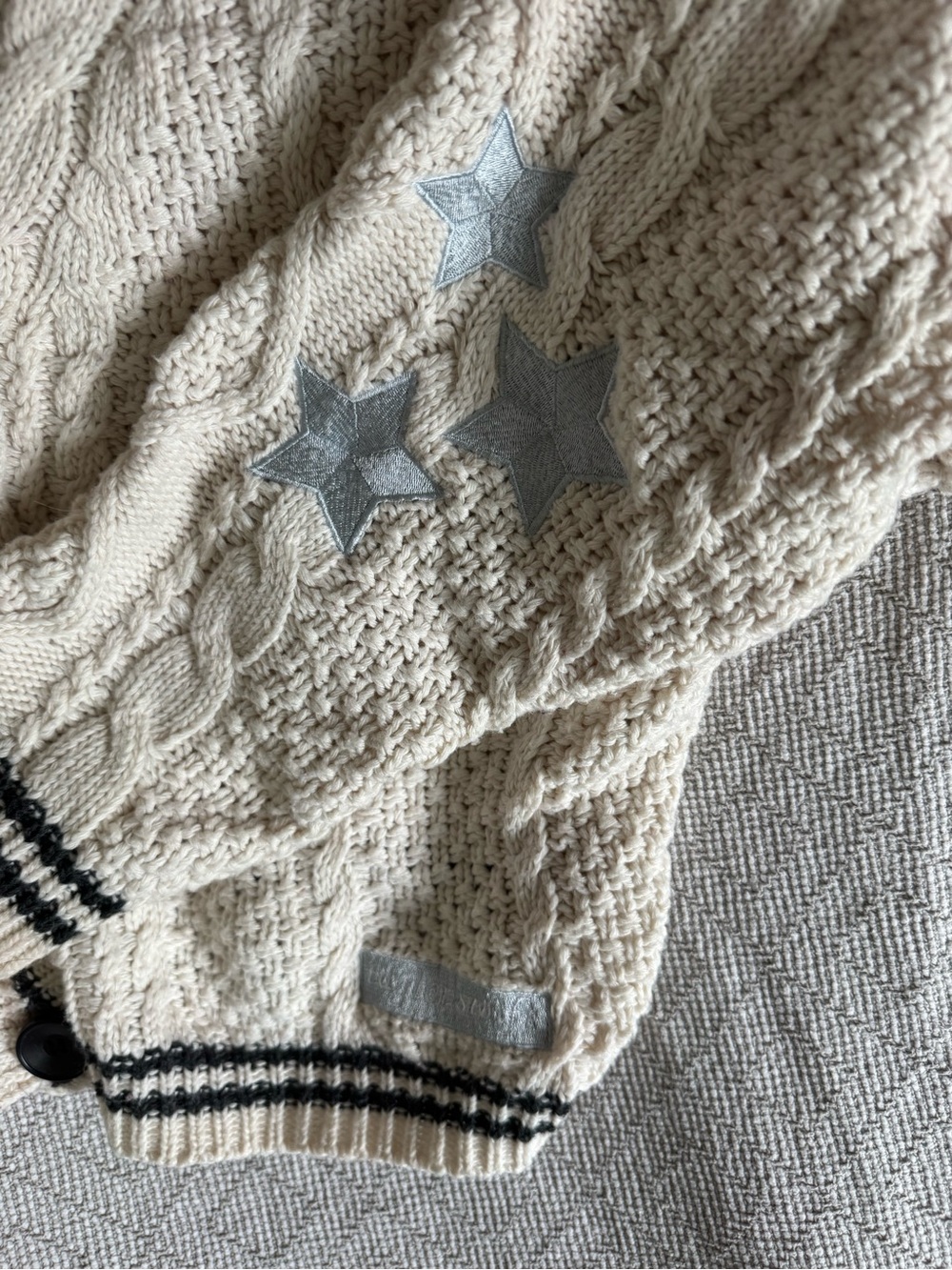 Taylor Swift Cream Cable Knit Cardigan with Black Trim and Silver Star Patches - Picture 3 of 5
